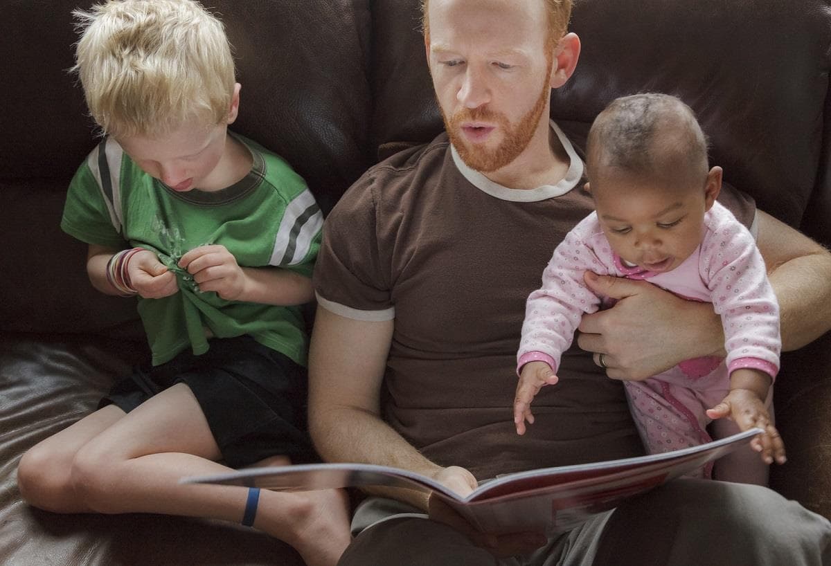dad reading to two kids one adopted