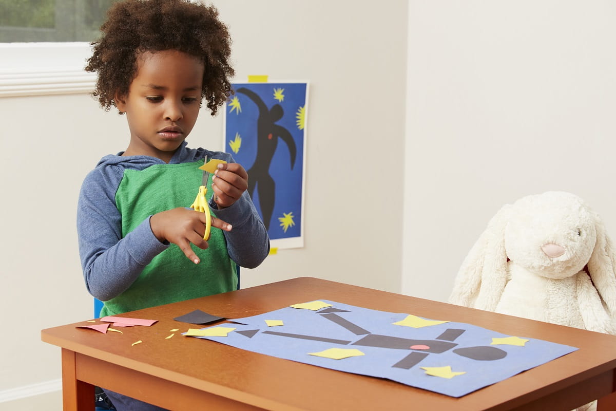 Toddler boy cutting shape with scissors