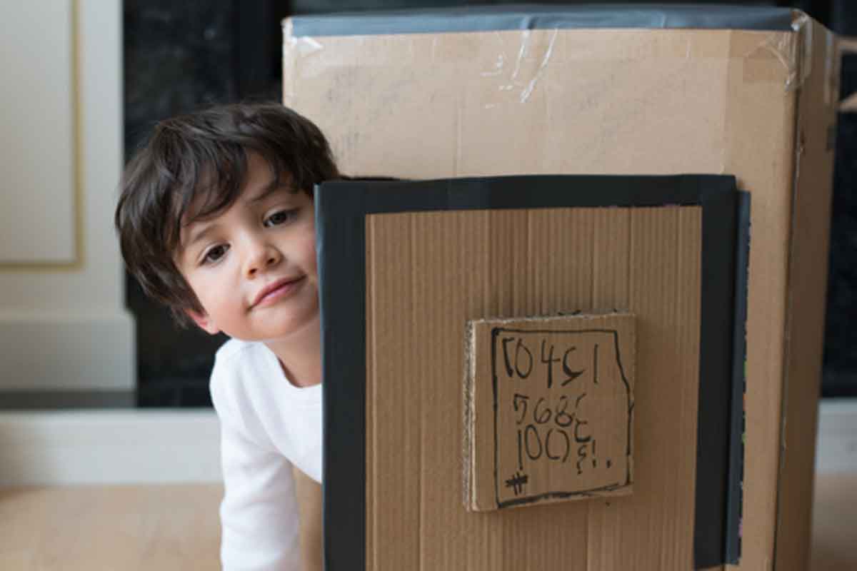 kid peeking out of cardboard box door