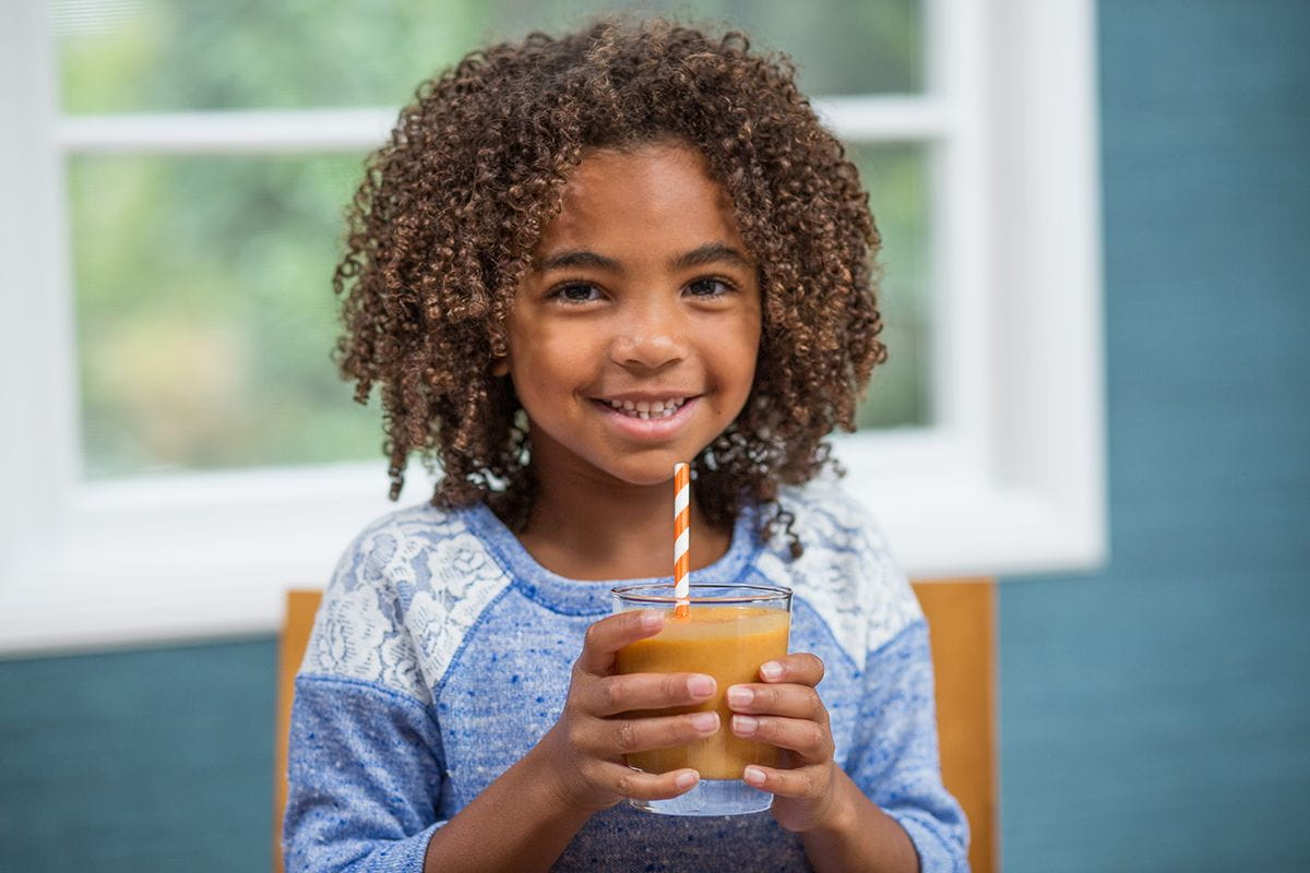 smiling girl with smoothie and a straw