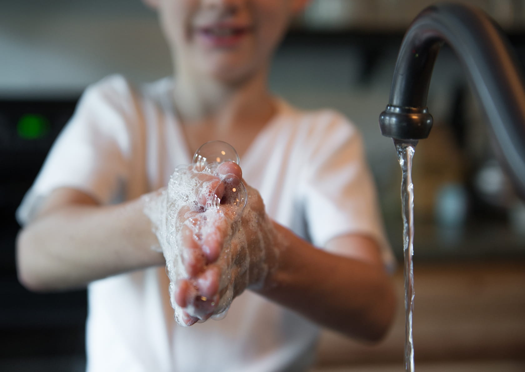 Boy washing sudsy hands