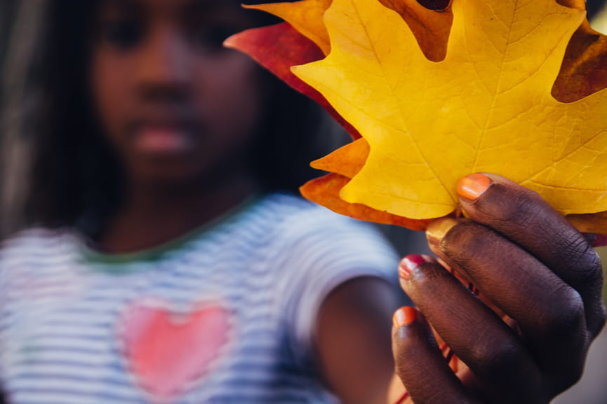 Young girl holding close up of leaves