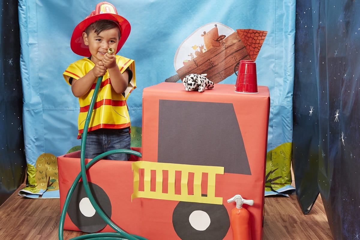 Toddler boy pretending to spray fire hose