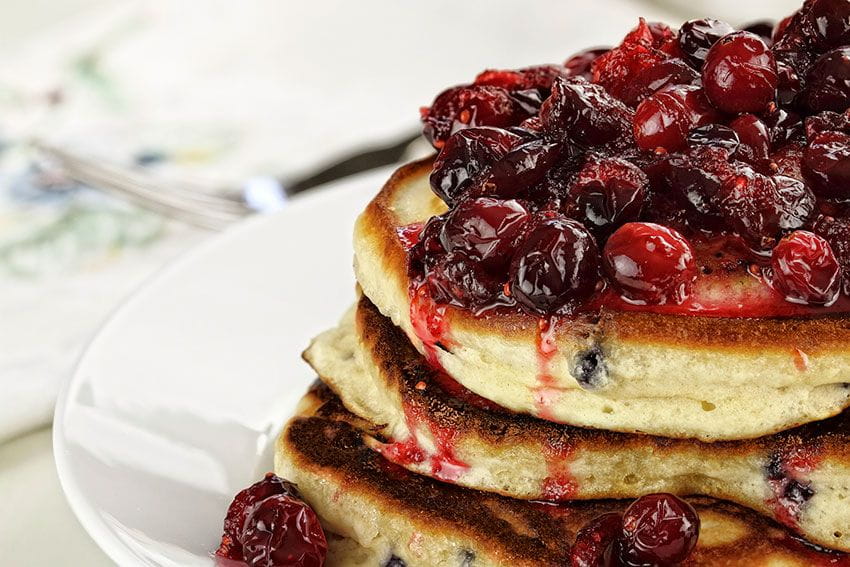 cranberry sauce on top of pancake stack Photo by Stephanie Frey / iStock