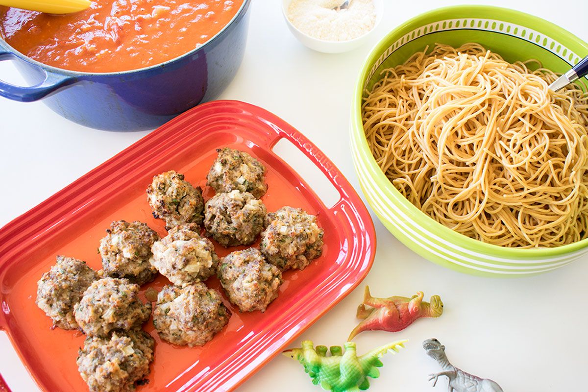 overhead shot of meatballs, pasta, and sauce in bowls