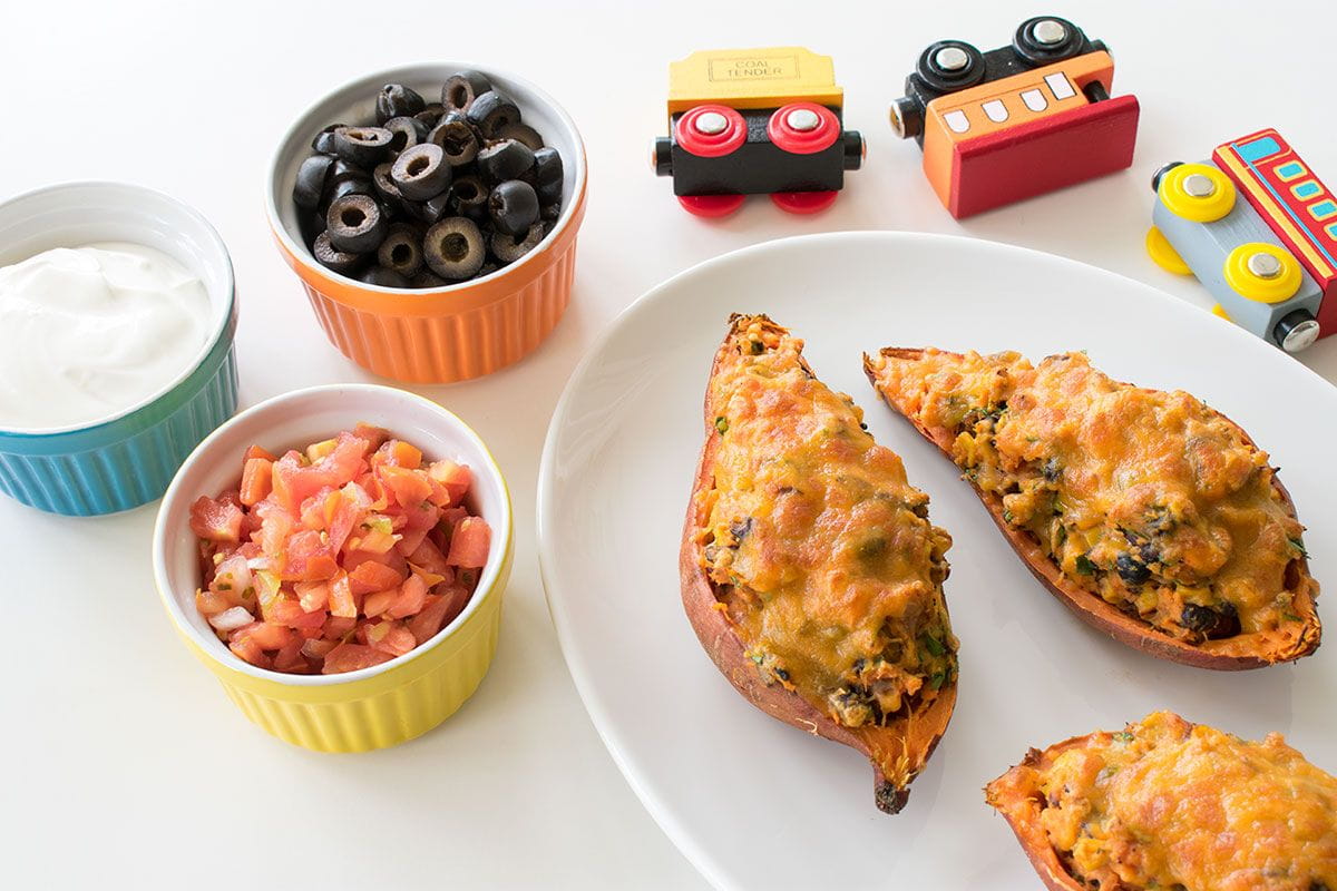 stuffed potatoes with tomatoes, black olives, and cream in bowls