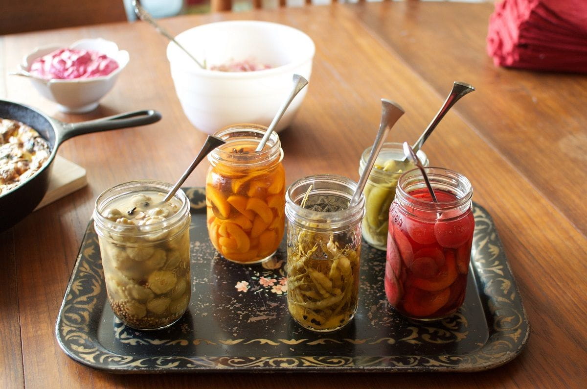 pickled produce in jars on a tray