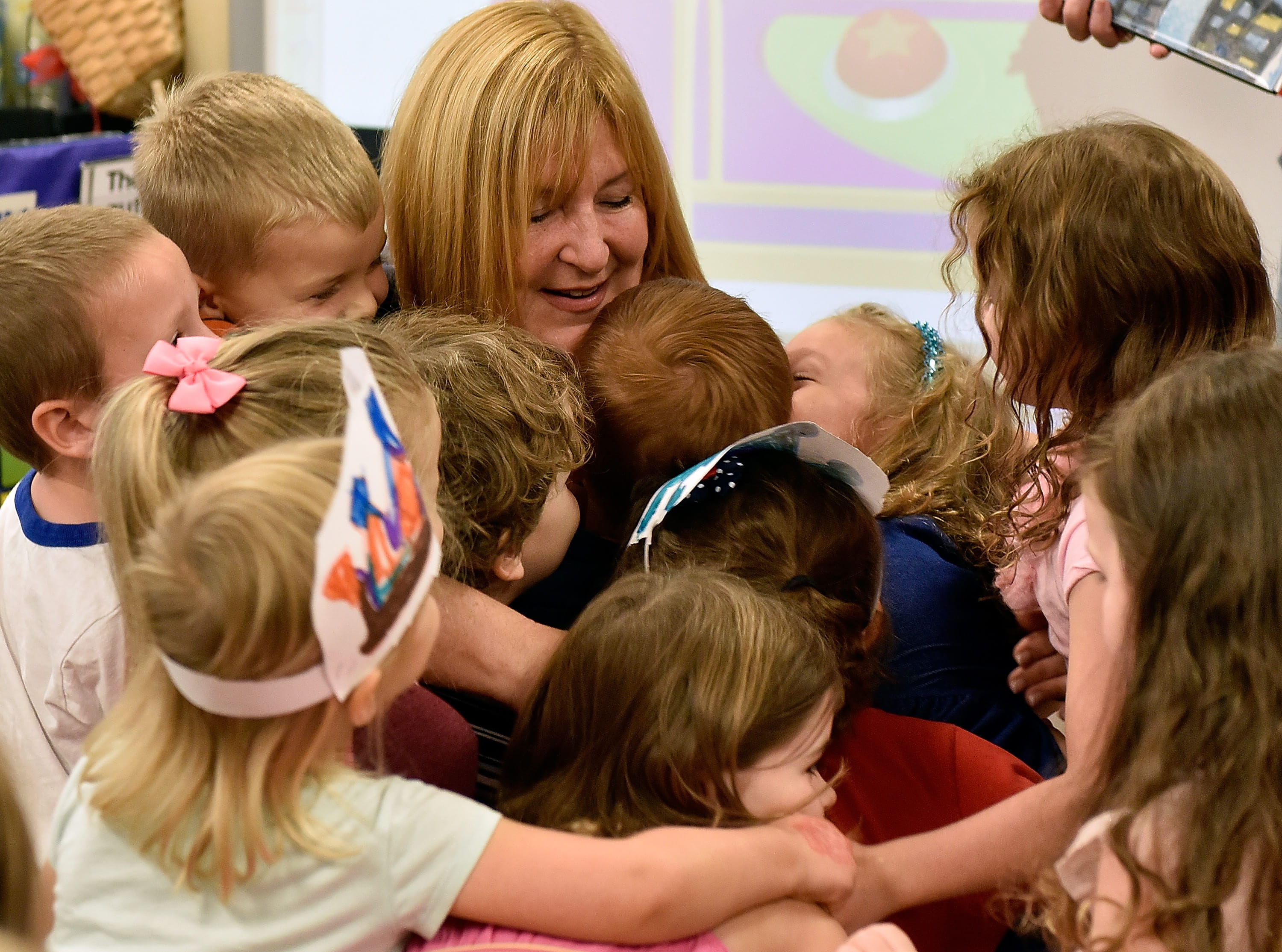 After winning an Early Childhood Educator Award, preK teacher Sue Davies was engulfed by warm hugs. Photo by Getty Images