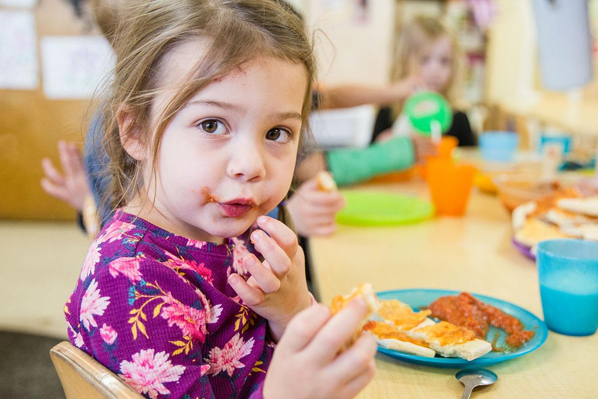 little girl with ravioli sauce on face