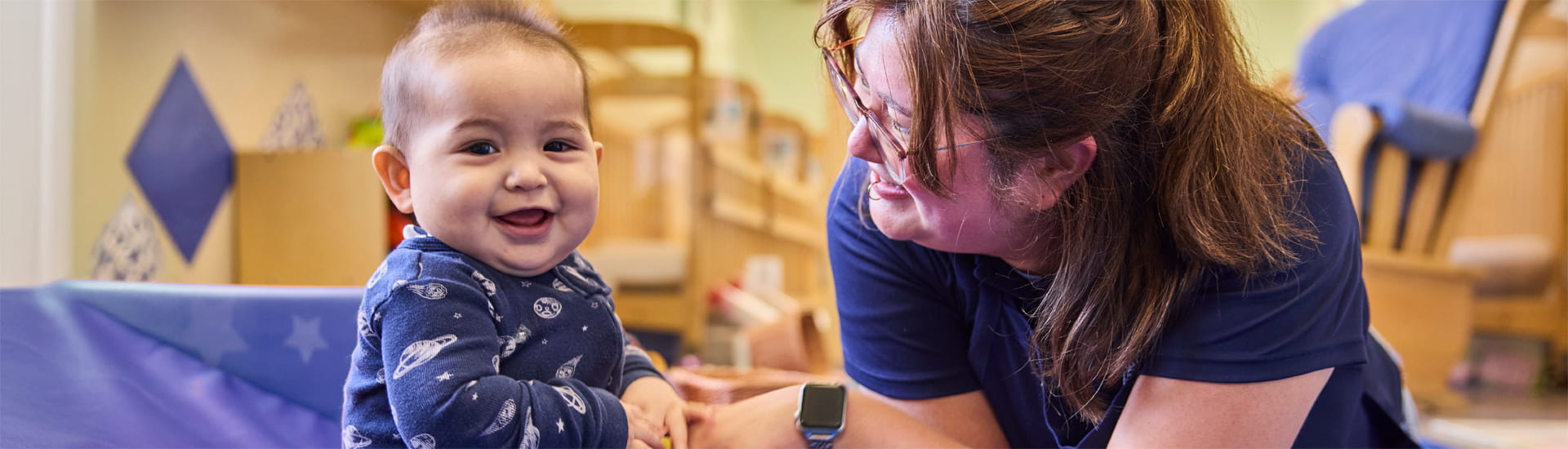 KinderCare teacher with infant in classroom