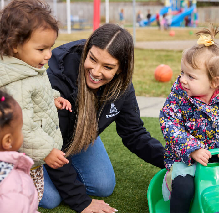teacher playing outside with toddlers