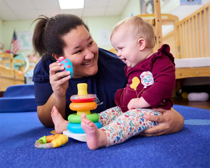 infant teacher stacking rings with baby