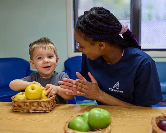 teacher providing nutritious foods to preschool kid