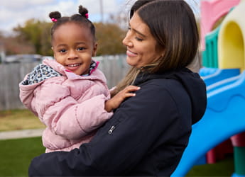teacher holding kid at the playground