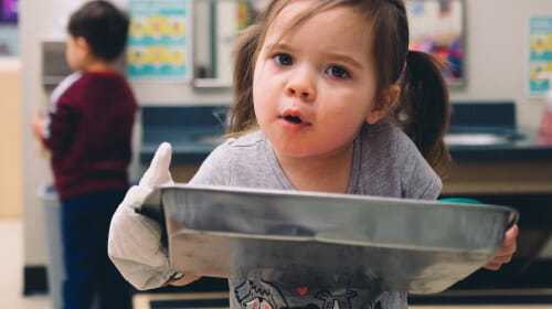 toddler with cooking tray
