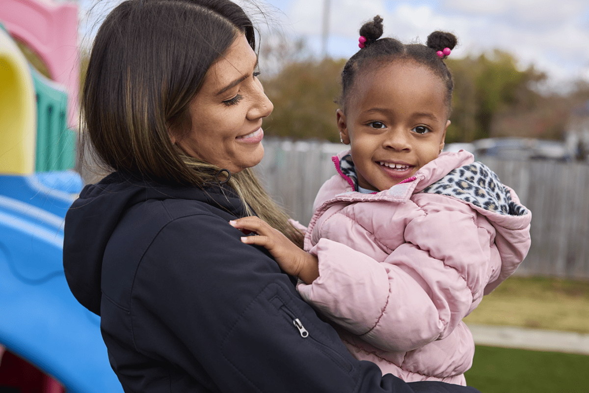 parent holding daughter on the playground