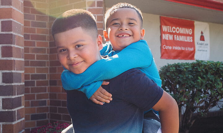 brothers smiling outside of daycare center